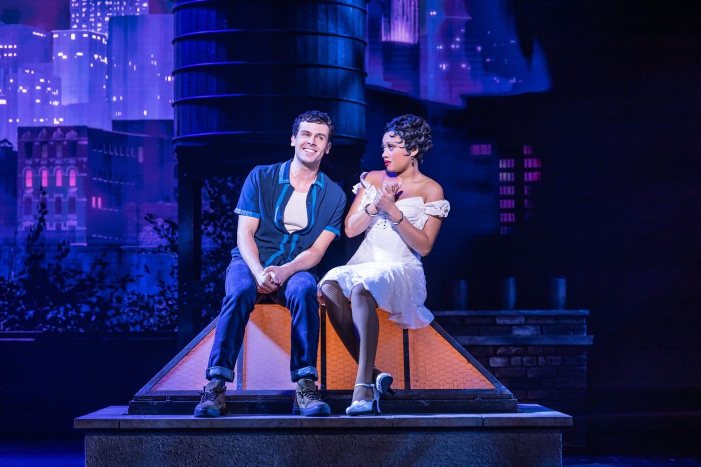 Betty Boop and a man sit together on a rooftop set with video content showing a city skyline.