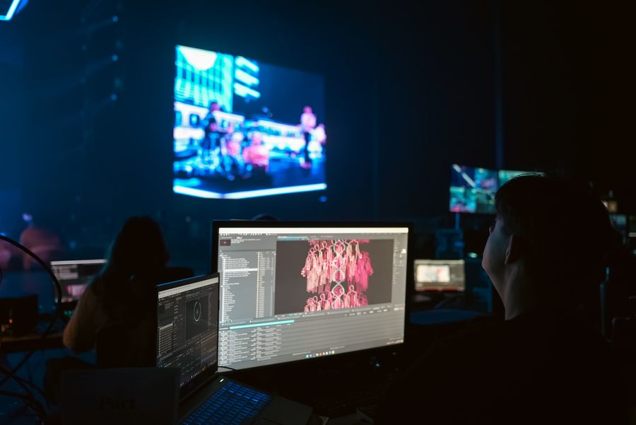 Person working at computer while looking at their work on stage