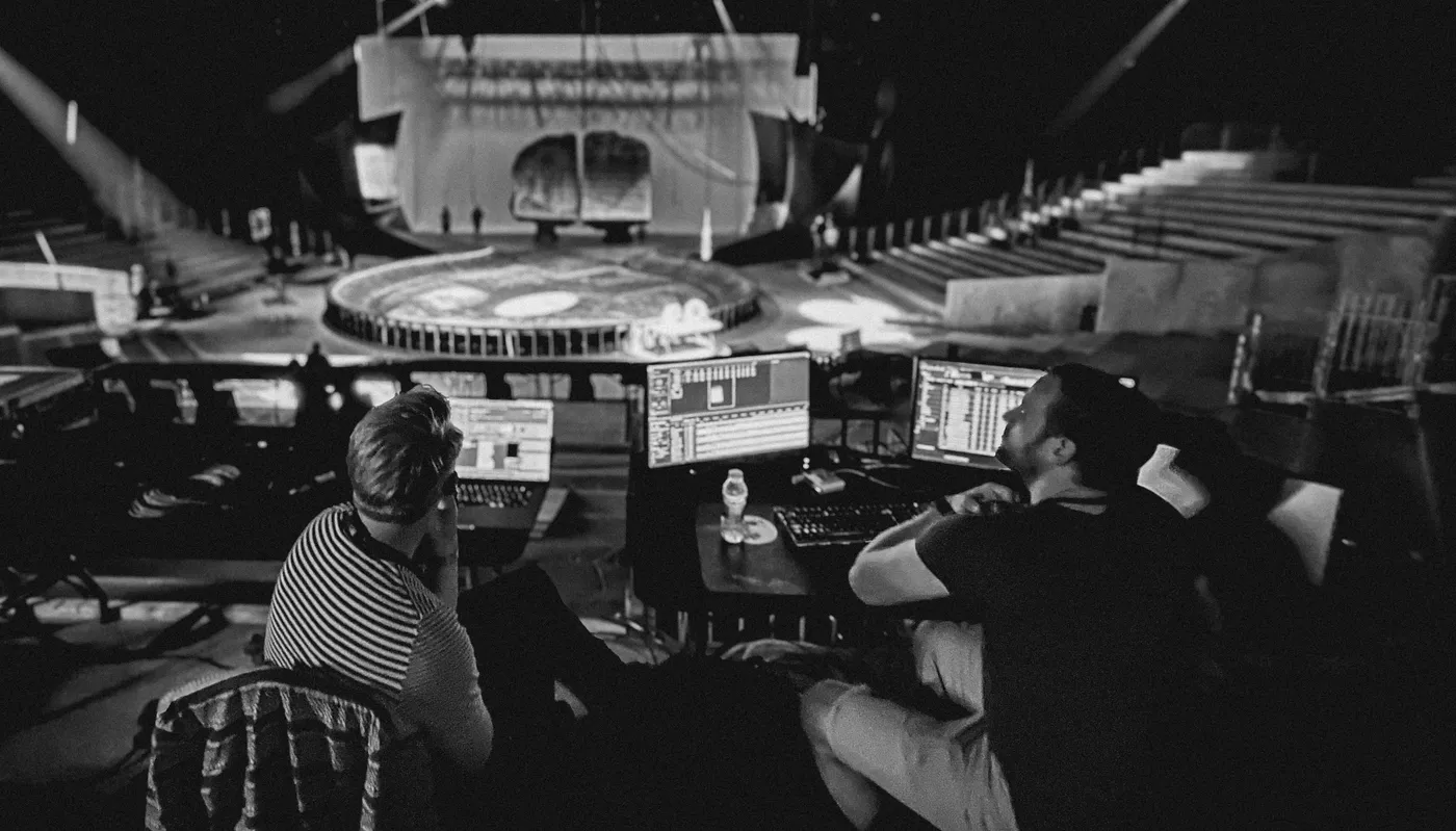 Two people sat in thoughtful discussion looking at the stage