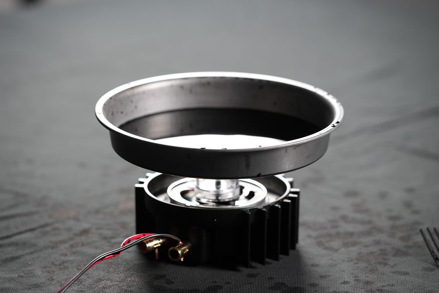 Cymatics speaker set up with a cake pan with black liquid in it