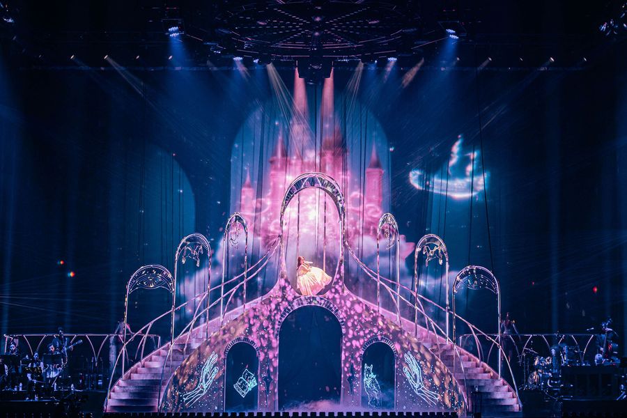 Laufey on a swing with pink castle visuals, designed by FRAY Studio.