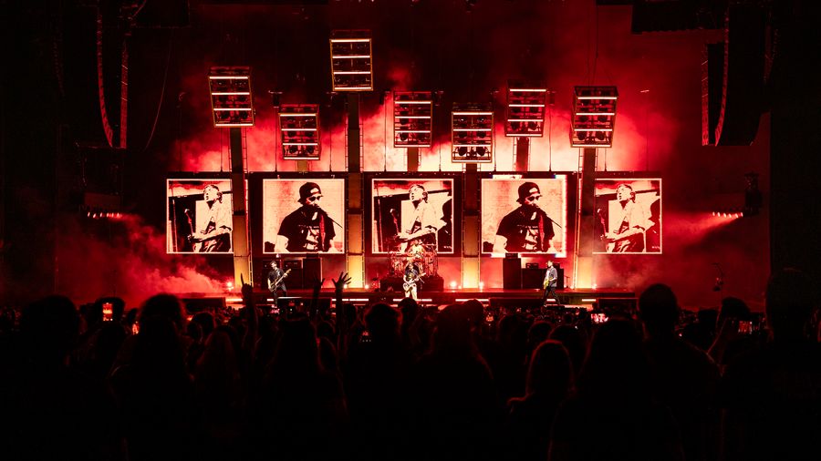 5 large led screens in black, white and red showing different framings of the band