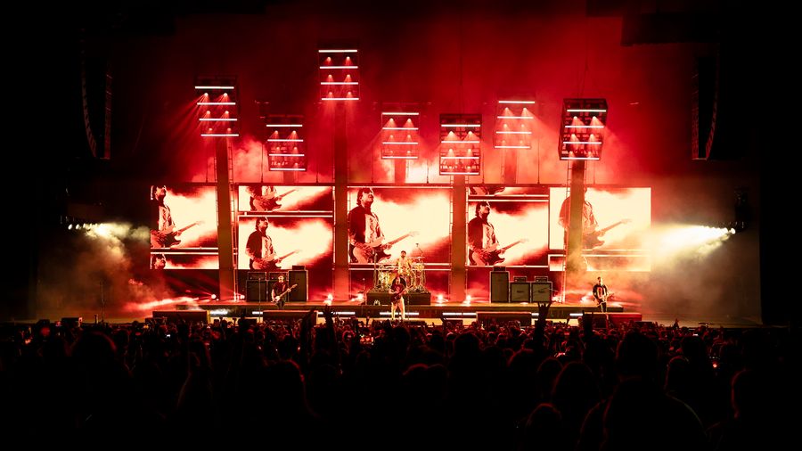  5 large screens on stage with red, black and while live footage of the band Pierce the Veil designed on to them. 